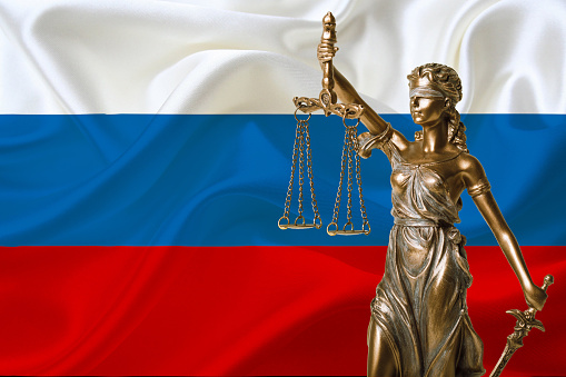 statue of justice and russia flag