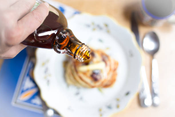 istock Hand Pouring Syrup on Blueberry Pancakes 1070057642