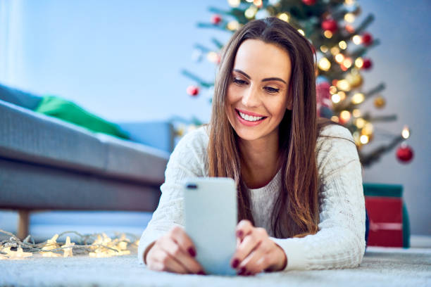 istock Happy woman using smartphone during Christmas, texting message 1070058126