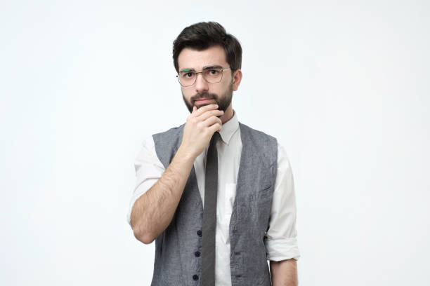 istock Handsome young hispanic man looking pensive while standing against white background 1070058150