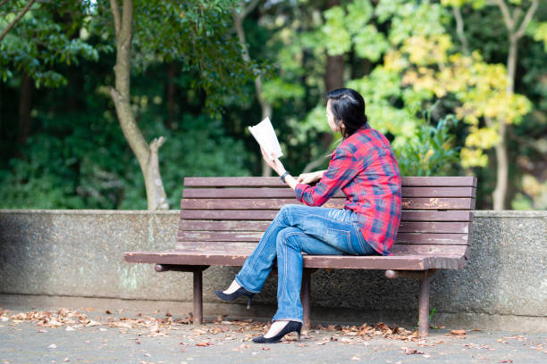 Woman reading a book on a park bench
