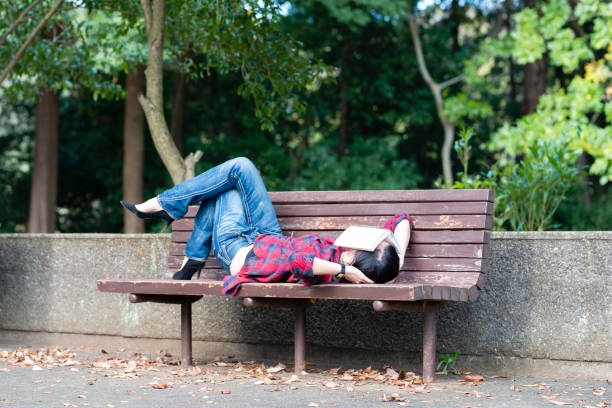 istock Women who take a nap on a bench in the park 1070058620