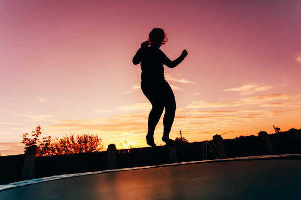 istock Silhouette Woman Jumping On Trampoline Against Sky During Sunset 1070060796