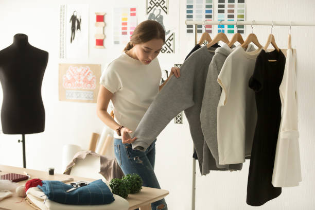 дизайнер женской одежды, работающая с новой женщиной, носит в мастерской - retail workshop store tailor стоковые фото и изображения