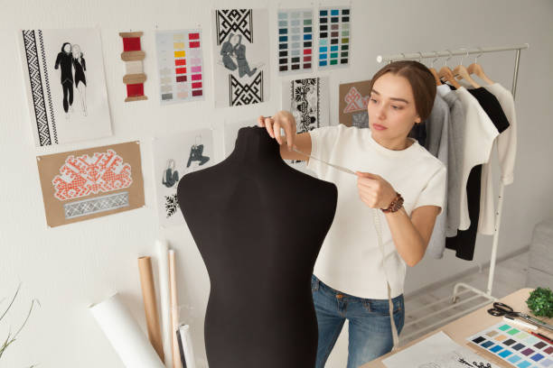 istock Female clothes designer taking dummy, mannequin measurements 1070060834