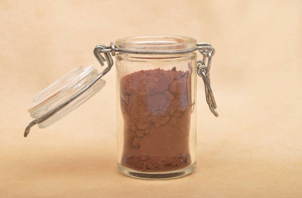 istock Cacao powder in  jar with lid on brown background 1070065328
