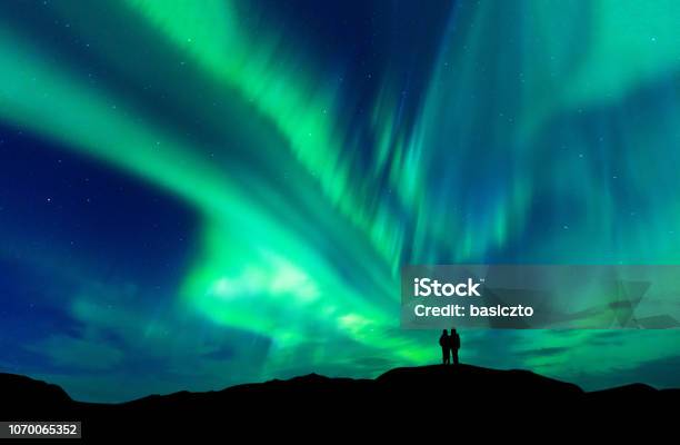 Aurora Borealis With Silhouette Love Romantic Couple On The Mountainhoneymoon Travel Concept Stock Photo - Download Image Now