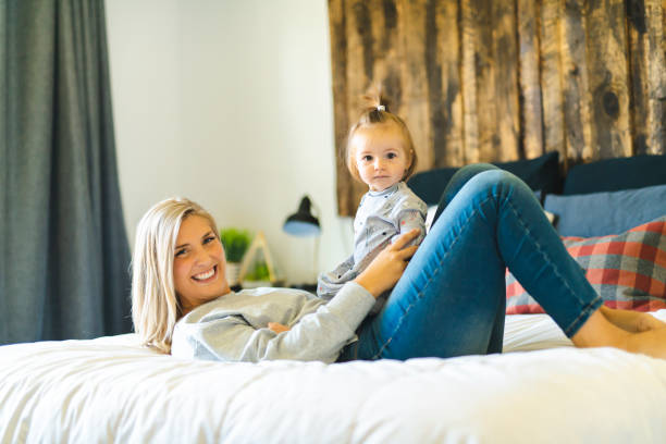 istock Mother and his baby daughter on bed having fun 1070065450