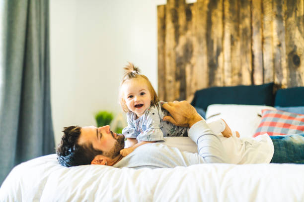 istock Father and his baby daughter on bed having fun 1070065826