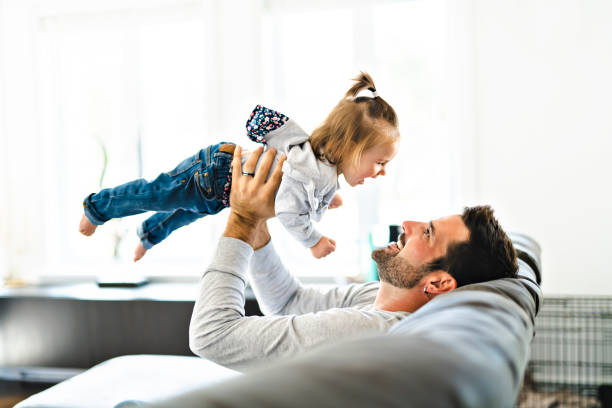 istock Young father with baby daughter on sofa at home 1070066534