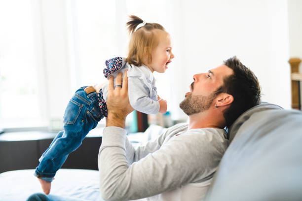 istock Young father with baby daughter on sofa at home 1070066542