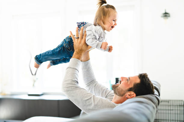istock Young father with baby daughter on sofa at home 1070066638