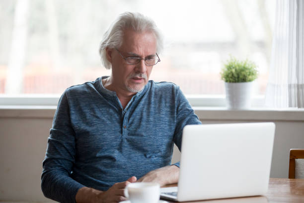 istock Confused aged man disappointed by negative online news 1070066652