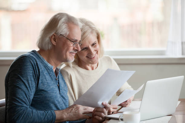 istock Happy aged couple satisfied with easy online banking using laptop 1070068074