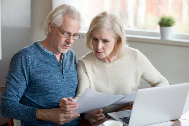 istock Serious elder husband and wife read bank documents at home 1070068118