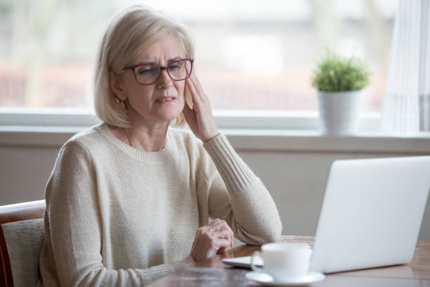 istock Tired senior woman suffering from headache working at laptop 1070069238