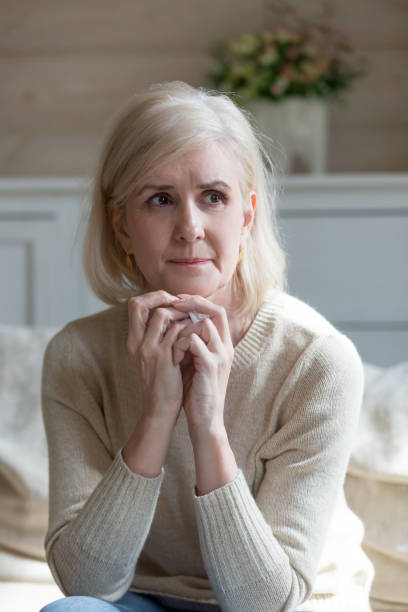 istock Upset old woman feeling lonely crying sitting on couch 1070069528
