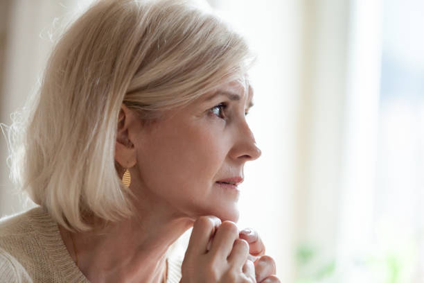 istock Sad aged woman crying near window feeling lonely 1070069538