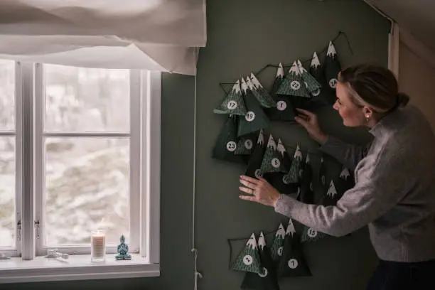 Woman with christmas calendar with gifts
At home with presents for each day of december