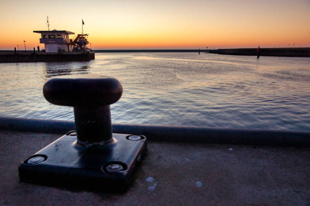 Empty unused mooring post in the Harlingen harbor in the North of the Netherlands. Dams and under sunlight along the Wadden Sea and North Sea at the Netherlands