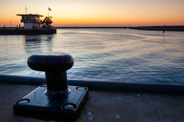 Empty unused mooring post in the Harlingen harbor in the North of the Netherlands. Dams and under sunlight along the Wadden Sea and North Sea at the Netherlands