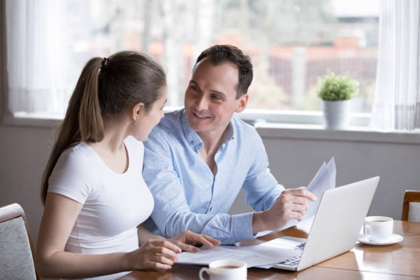 istock Happy wife and husband checking bills at home 1070078990