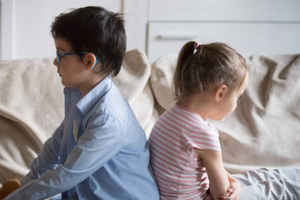 istock Gloomy children sitting on couch at home 1070078994