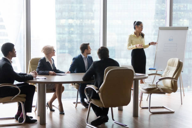 istock Young female employee present project on flipchart to colleagues 1070080078