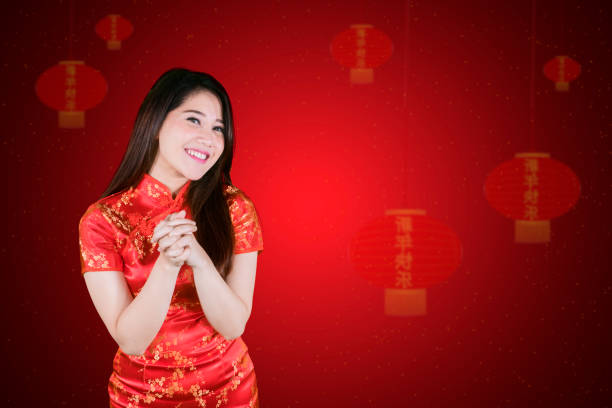 istock Chinese woman stands with congratulating gesture 1070080598