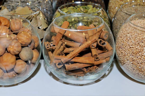 Spices in glass flasks: cinnamon sticks, nutmeg, coriander