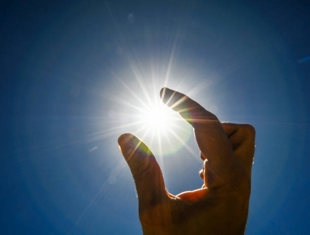 istock One Hand Catching the Sun Stars on a Blue Background 1070084280