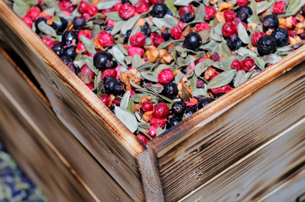 сухой фруктовый чай, смешать с листьями, ягодами в деревянной коробке - organic dried fruit berry fruit dried food стоковые фото и изображения