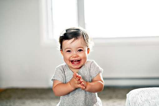 Little cute Asian baby boy with suspicious look and innocence while waiting for his father to cut his hair.