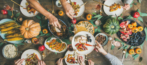 istock Friends feasting at Thanksgiving Day table with turkey, wide composition 1070085906