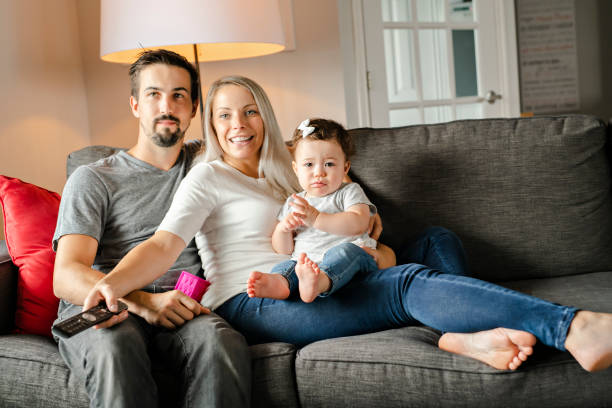 family mother, father, child daughter at home watching tv - domestic life young family family child imagens e fotografias de stock