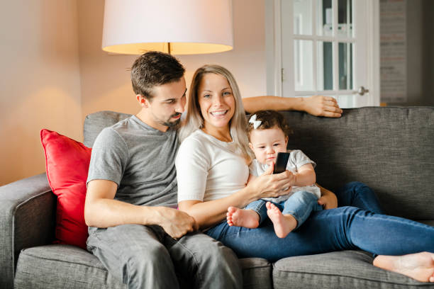 family mother, father, child daughter at home watching tv - domestic life young family family child imagens e fotografias de stock