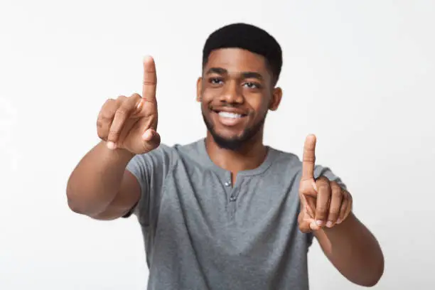 Photo of Black man touching on transparent screen interface