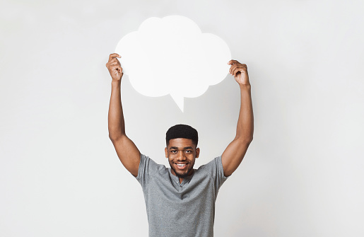 Happy african-american man holding blank speech bubble above his head, inspiration and idea concept, copy space