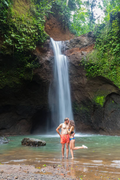 istock couple looking at the gorgeous waterfall in Bali 1070089546