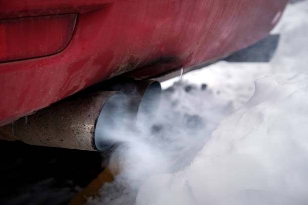 the exhaust gases of the car white thick smoke from the chimney in the winter the exhaust gases of the car white thick smoke from the chimney in the winter against the white snow, pollution ecology smog car stock pictures, royalty-free photos & images