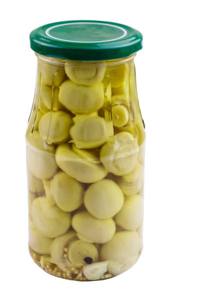 Delicious marinated mushrooms in glass jar isolated on white background