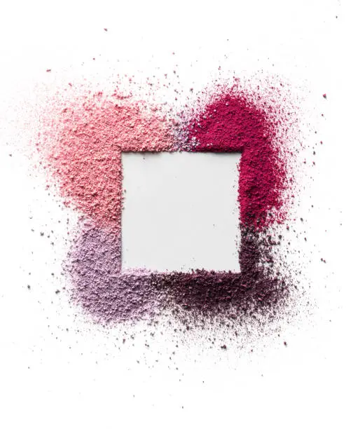 Scattered eyeshadow and blush for the face in the form of a square frame with space for text. Isolated on white background. Cosmetic concept
