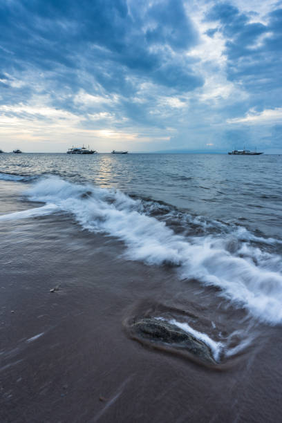 rock sur la plage dans le ciel de l’aube - long exposure rock cloud sky photos et images de collection