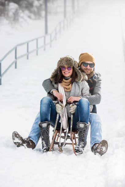 istock Young couple having fun with sled on winter vacation 1070111280