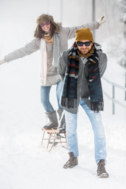 istock Young couple playig with sled on winter vacation 1070111358