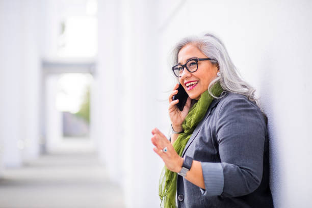 Senior Hispanic Businesswoman on the Phone A senior hispanic businesswoman at the conference center scarf photos stock pictures, royalty-free photos & images