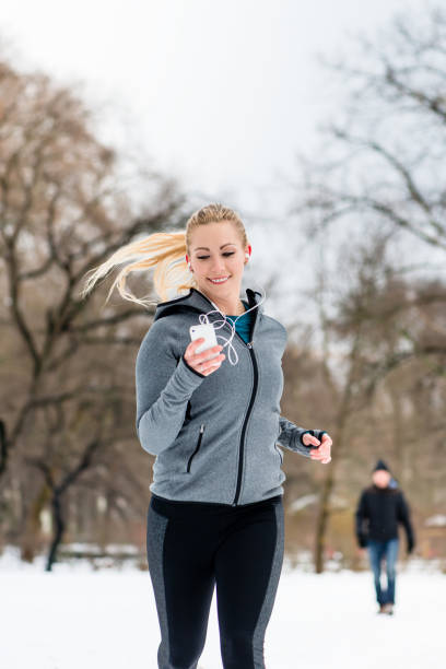 istock Woman running down a path on winter day in park 1070115286