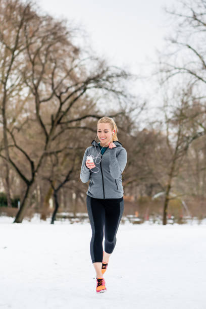 istock Woman running down a path on winter day in park 1070115388