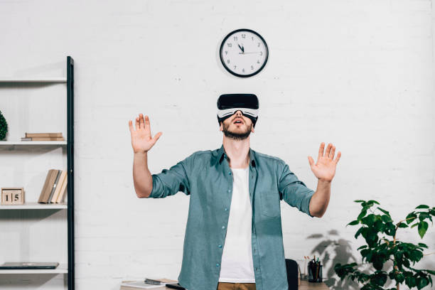 istock selective focus of young man with wide arms using virtual reality headset at home 1070118196