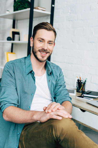 istock smiling young man looking at camera while sitting near table 1070118484
